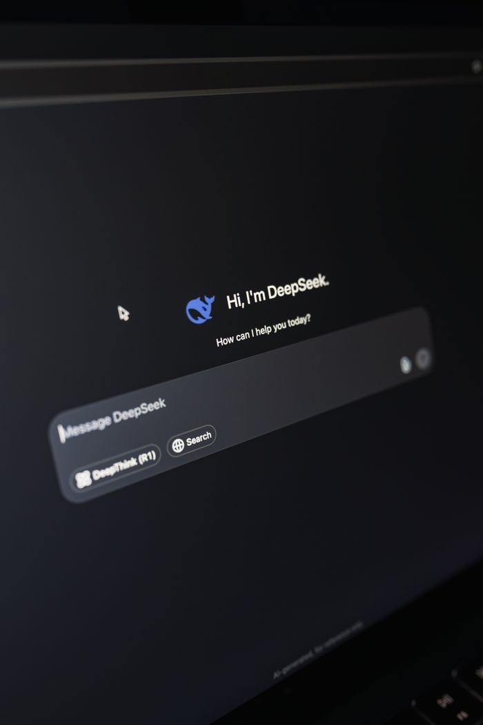 首页 Close-up of a laptop displaying an AI interface with a chatbot prompt in dark mode.